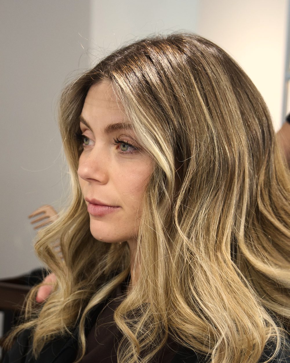 Melena rubia con balayage y ondas, de perfil